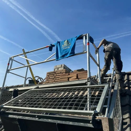 Dakdekker op een pannendak naast het platform van een ladderlift in Barneveld